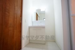 同仕様写真。三面鏡つき洗面台。収納も一体型になっているので、ドライヤーやヘアアイロンの置き場に困りませんね。