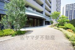 エントランス外。エントランスの自動ドアと出入り口に段差のないバリアフリー対応です。きれいに保たれたエントランスが安らぎに満ちた暮らしへ誘います。