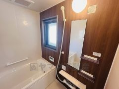 木目調パネルが落ち着きを演出するバスルーム。