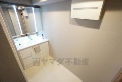 三面鏡付きの洗面台。白くて清潔感がありますね。収納スペースも広く、洗剤や掃除道具をたっぷりと収納できます。