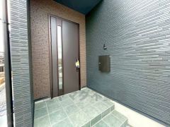 木目調がとてもお洒落なタッチキータイプの玄関ドアです。奥まって設置されているので、雨に濡れる心配もありません。