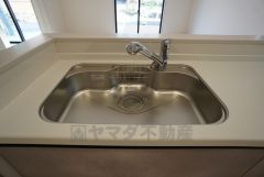 大きな鍋などもラクラク洗えるワイドサイズを採用。排水口が奥なので水の流れもスムーズです。浄水器内蔵型シャワー水栓つき。