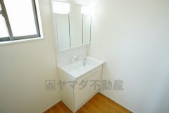 同仕様写真。三面鏡つき洗面台。収納も一体型になっているので、ドライヤーやヘアアイロンの置き場に困りませんね。