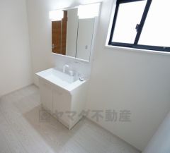 同仕様写真。三面鏡つき洗面台。収納も一体型になっているので、ドライヤーやヘアアイロンの置き場に困りませんね。